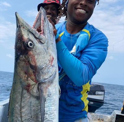 a man holding a fish on a boat