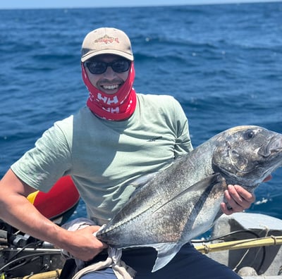 a man in a bandannard is holding a fish