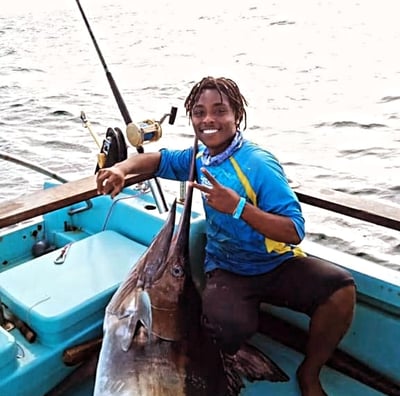 a man holding a fish on a boat