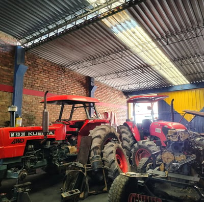 a tractor with a man standing in a garage