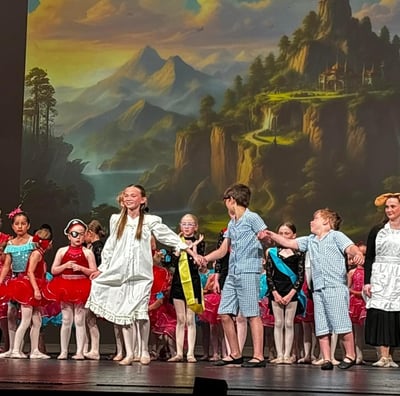 a group of children and adults in costume on stage