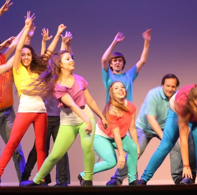 a group of parents and kids dancing on a stage