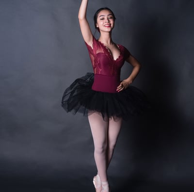 Teen ballerina in a red leotard and ballet shoes