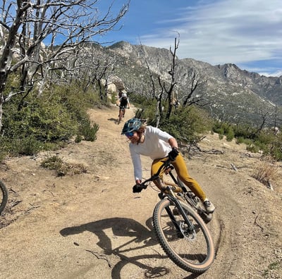 a man riding a bike on a dirt road