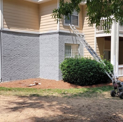"Exterior house painting project in progress with industrial spray machine and ladder, by Garnet Painting & Remodeling in Dou
