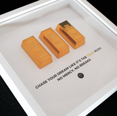 white frame with gold bars and motivational sentence