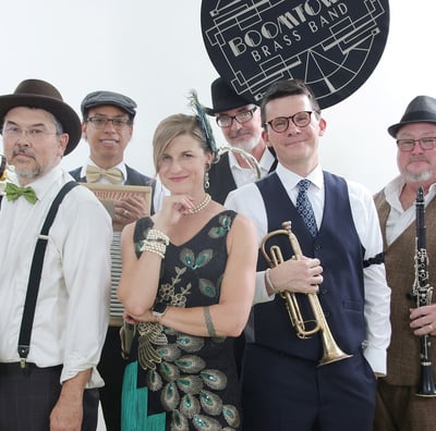 Promotional picture of Boomtown Brass Band, with trumpeter and other musicians in period clothing