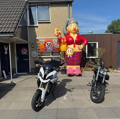 Opblaas pop Sarah gekleed in het rood aan de voorkant van een huis