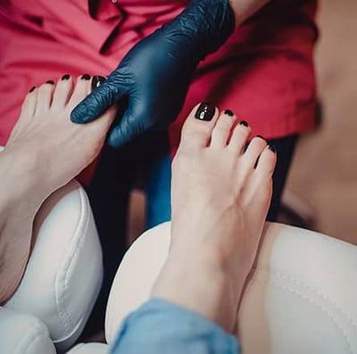 a woman getting her nails done by a professional nail technician