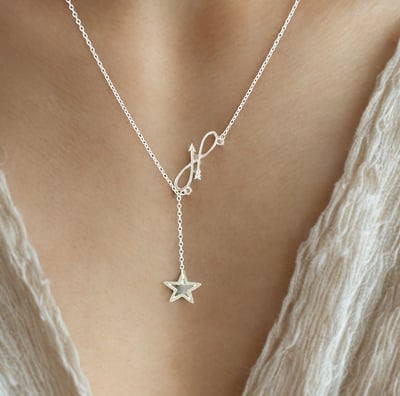 a woman wearing a necklace with a starfish charm
