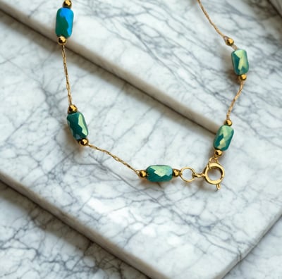 a bracelet bracelet with a gold chain and green beads