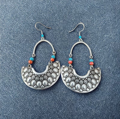 a pair of earrings with beads and pearls