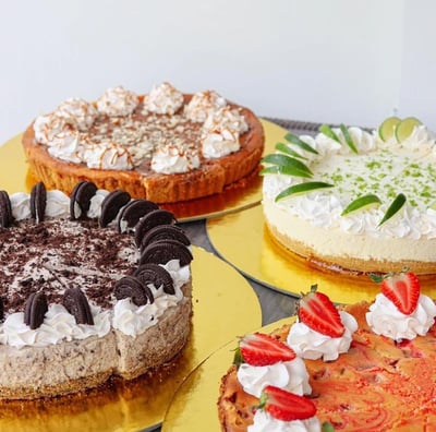 a variety of cakes on plates with strawberries