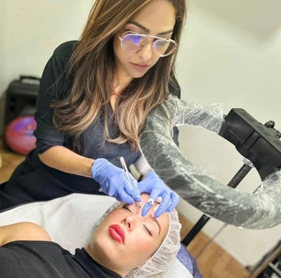 a woman getting her eyebrows done by a professional hairdresser