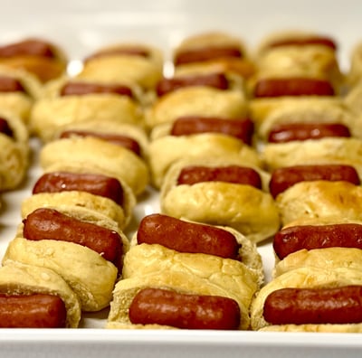 Platter full of cocktail sausages in Lil Smoky buns sitting in rows.