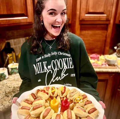 Smiling woman holding a party platter of little smokies in Smoky Lil Buns