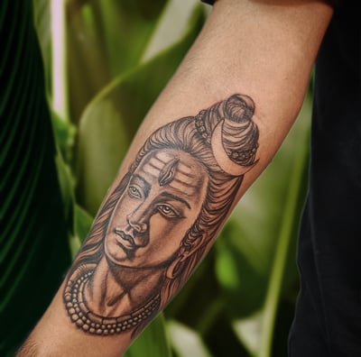 a man with a shiva tattoo on his arm