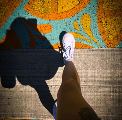 a person standing on a skateboard with their feet on the ground