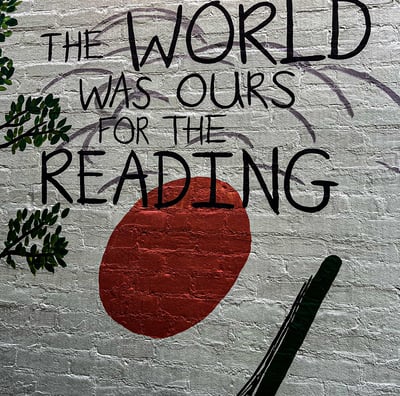 a wall mural of a book with a red sun in the background