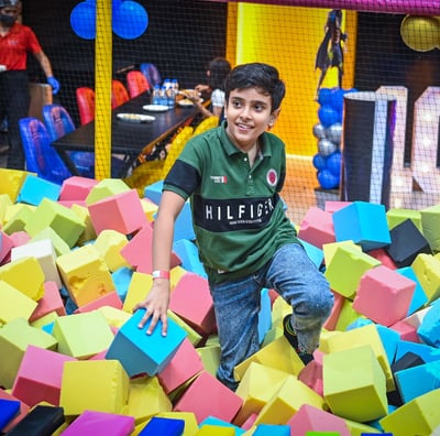 a boy is playing in a ball pit