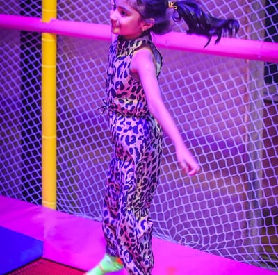 a girl in a leopard print jumpsuit and neon green shoes