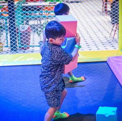 a young boy playing with blocks on a trampoline