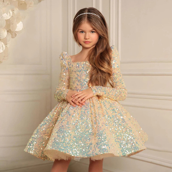 a young girl in a sparkly gold party dress
