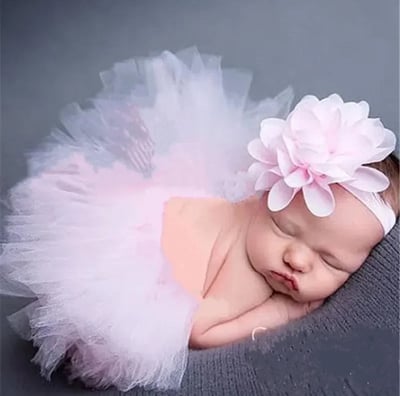 a baby girl sleeping in a pink tutu with a matching headband
