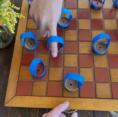 uma pessoa jogando damas em uma placa de madeira