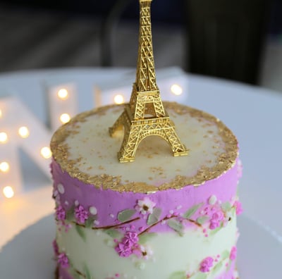 a cake with a gold eiffel tower in the background