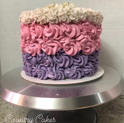 a cake with a pink and purple cake with white and pink flowers