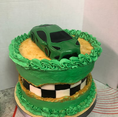 a cake with a green car on top of a cake