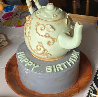 a cake with a teapot on top of a cake