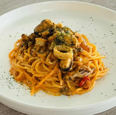 Italian seafood spaghetti served with mussels, squid, and herbs in a creamy tomato sauce