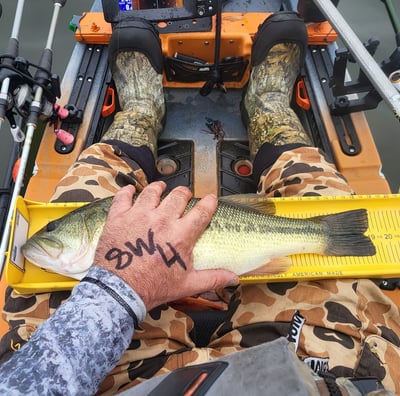 a person holding a fish on a kayak
