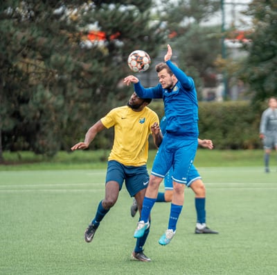 Duel de la tête entre deux joueurs pour récupérer le ballon