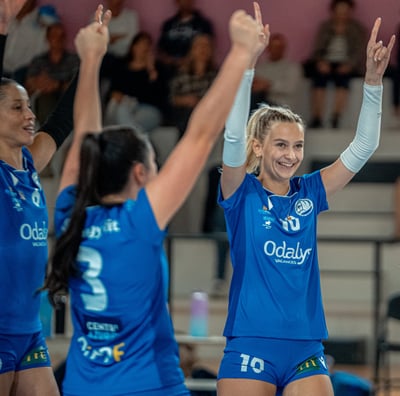 Trois joueuses qui lèvent les bras en souriant pour fêter un point