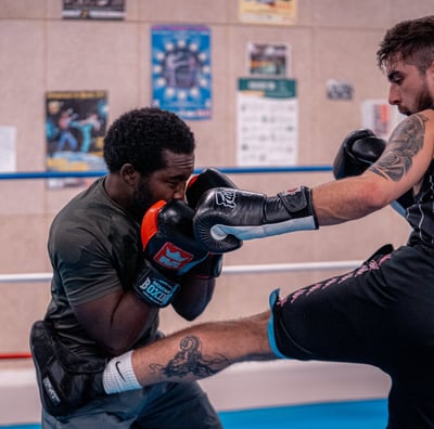 Boxeur qui met un coup de pied à son adversaire qui se défend