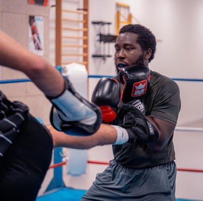 Boxeur qui se défend d'un coup de pied dans le ventre