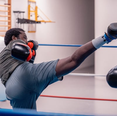 Boxeur qui essaye de mettre un coup de pieds dans la tête de son adversaire