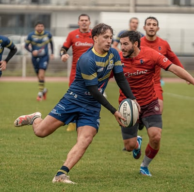 Joueur de Vélizy qui fait une passe avant de se faire plaquer