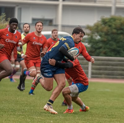 Joueur de rugby qui court et se fait plaquer