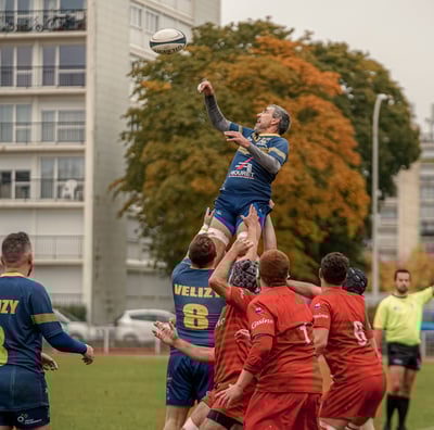 Joueur de rugby porté par ses coéquipiers pour récupérer une balle en touche