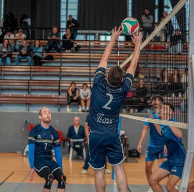 Joueur de Vélizy qui fait une passe en étant collé au filet