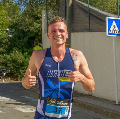Coureur qui court en souriant et en levant les pouces