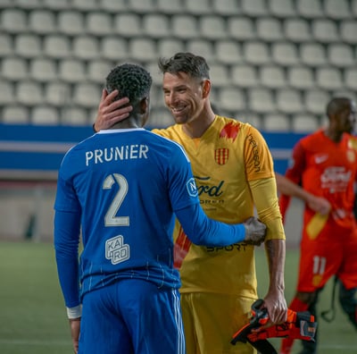 Gardien de Martigues et défenseur de Versailles qui font une accolade après le match