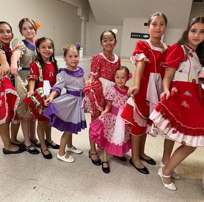 a group of young girls in dresses