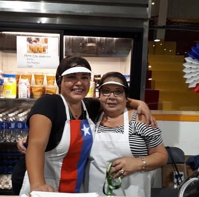 two women standing in front of a counter top