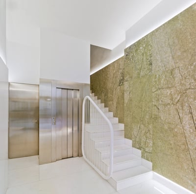 a staircase leading to a large, white tiled room