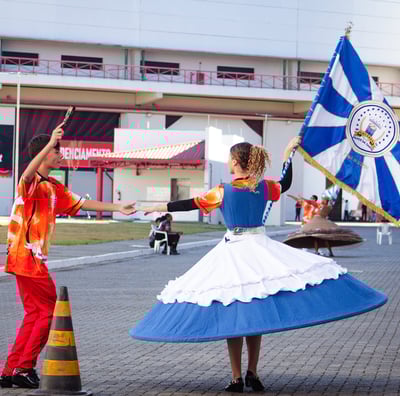 uma porta bandeira e um mestre sala ensaiando, a porta bandeira com o pavilhao da Filhos da Santa